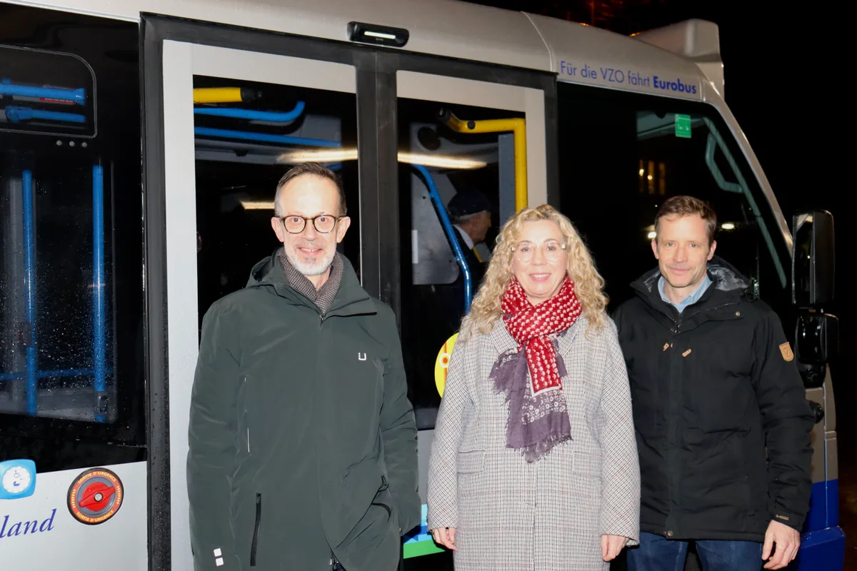 Zwei Männer und eine Frau vor dem Kleinbus.